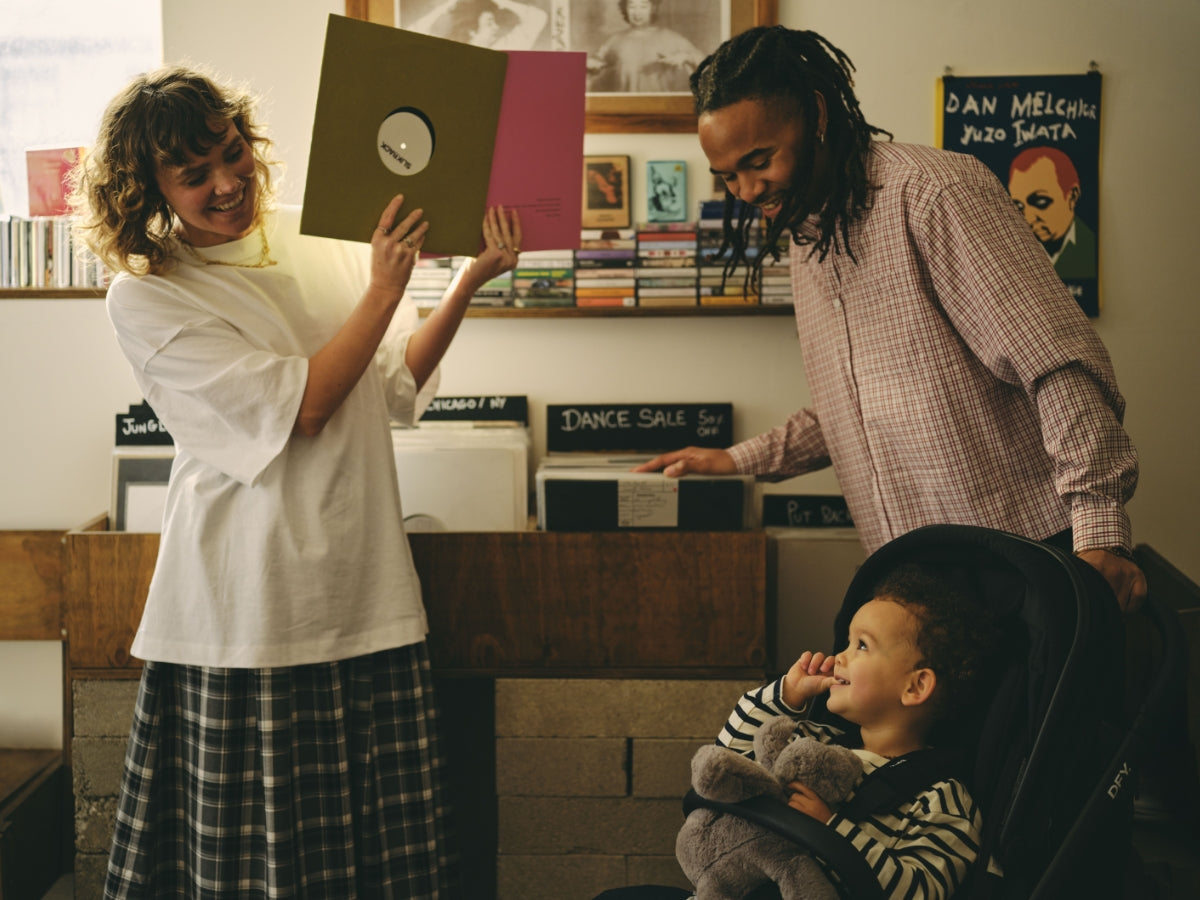 Image of mum playing peek-a-boo with records with her baby