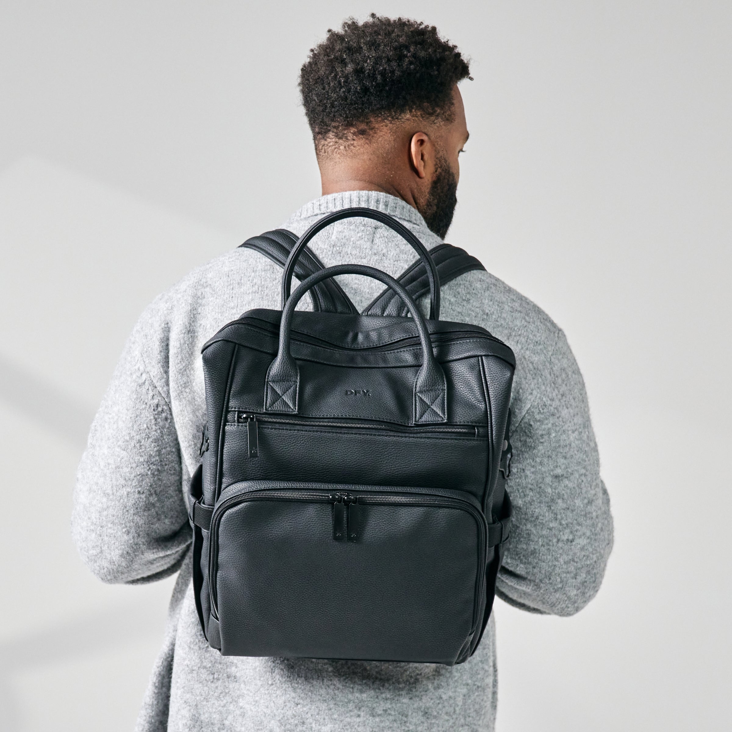 shot of dad wearing diaper backpack